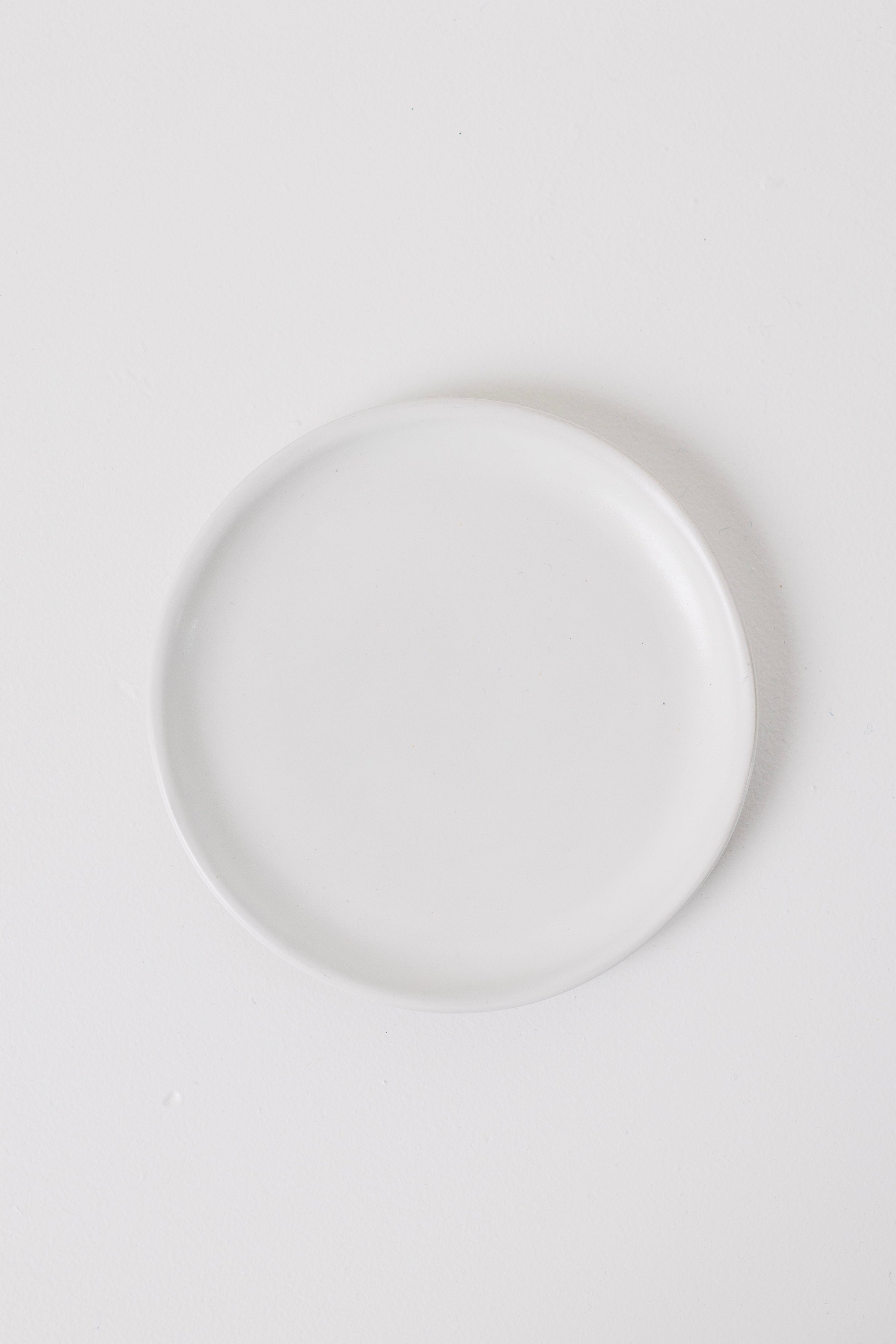 Minimalist matte white appetizer plates styled on a table