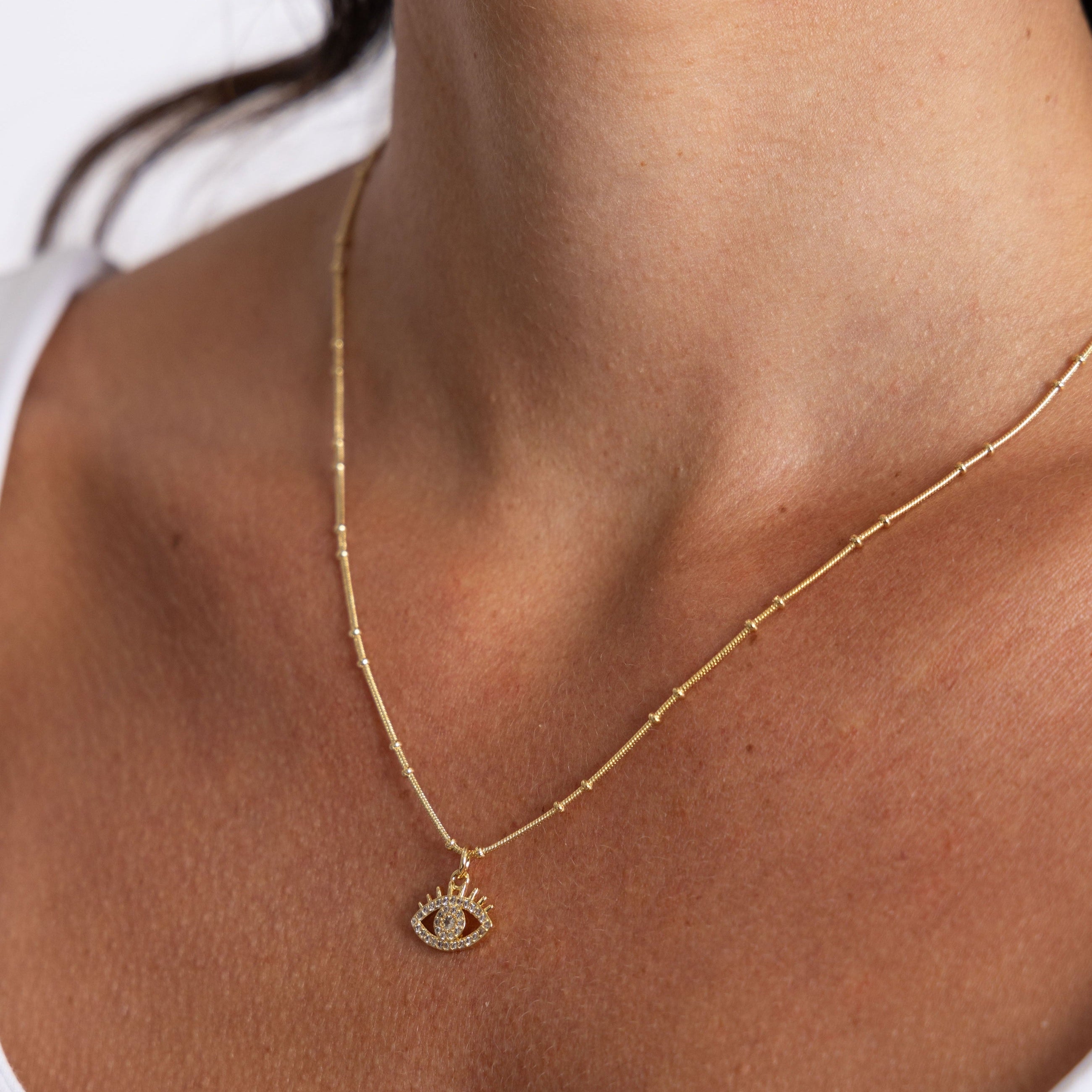 Gold evil eye necklace styled on model