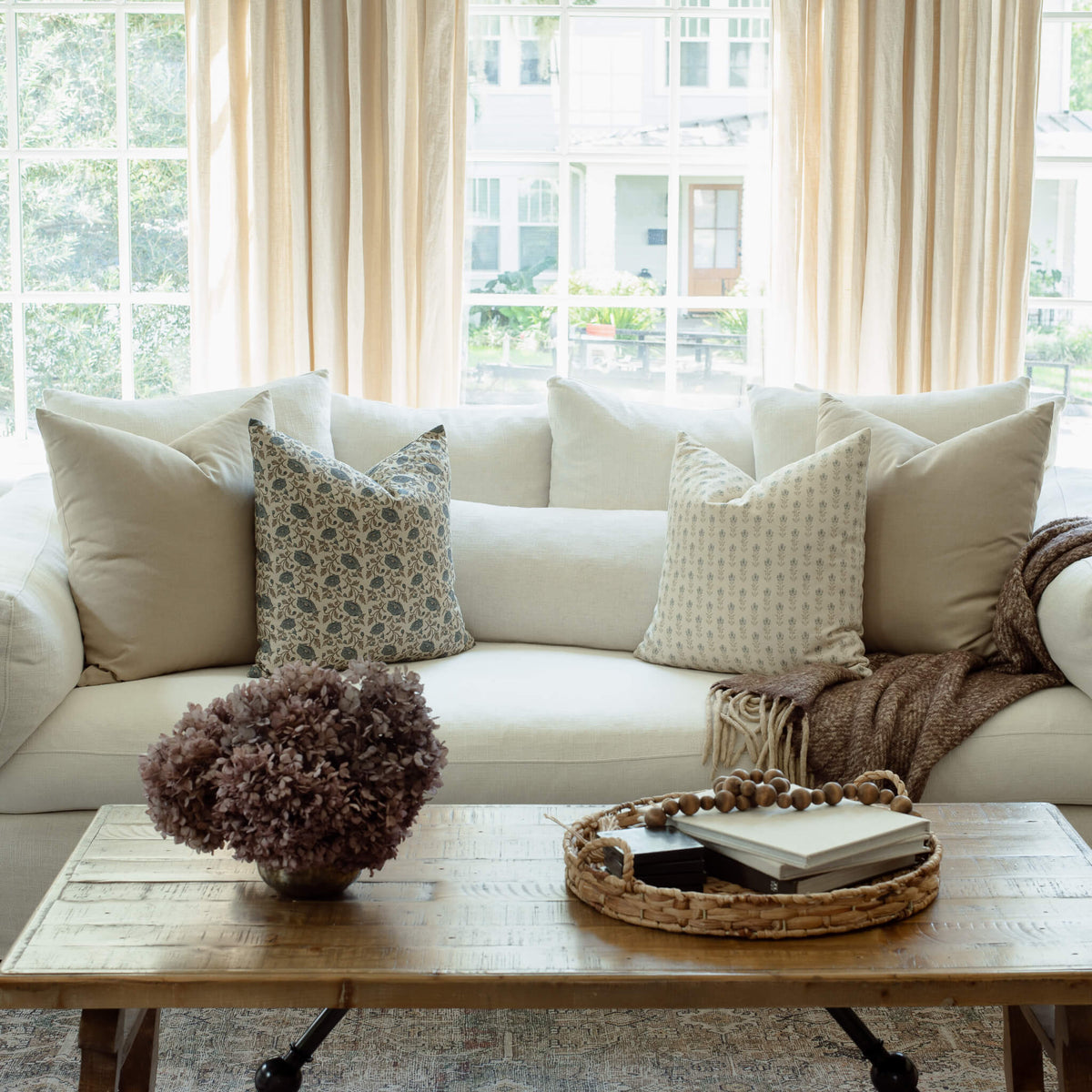 Stella blue floral pillow with ivory pillows in a bright living room