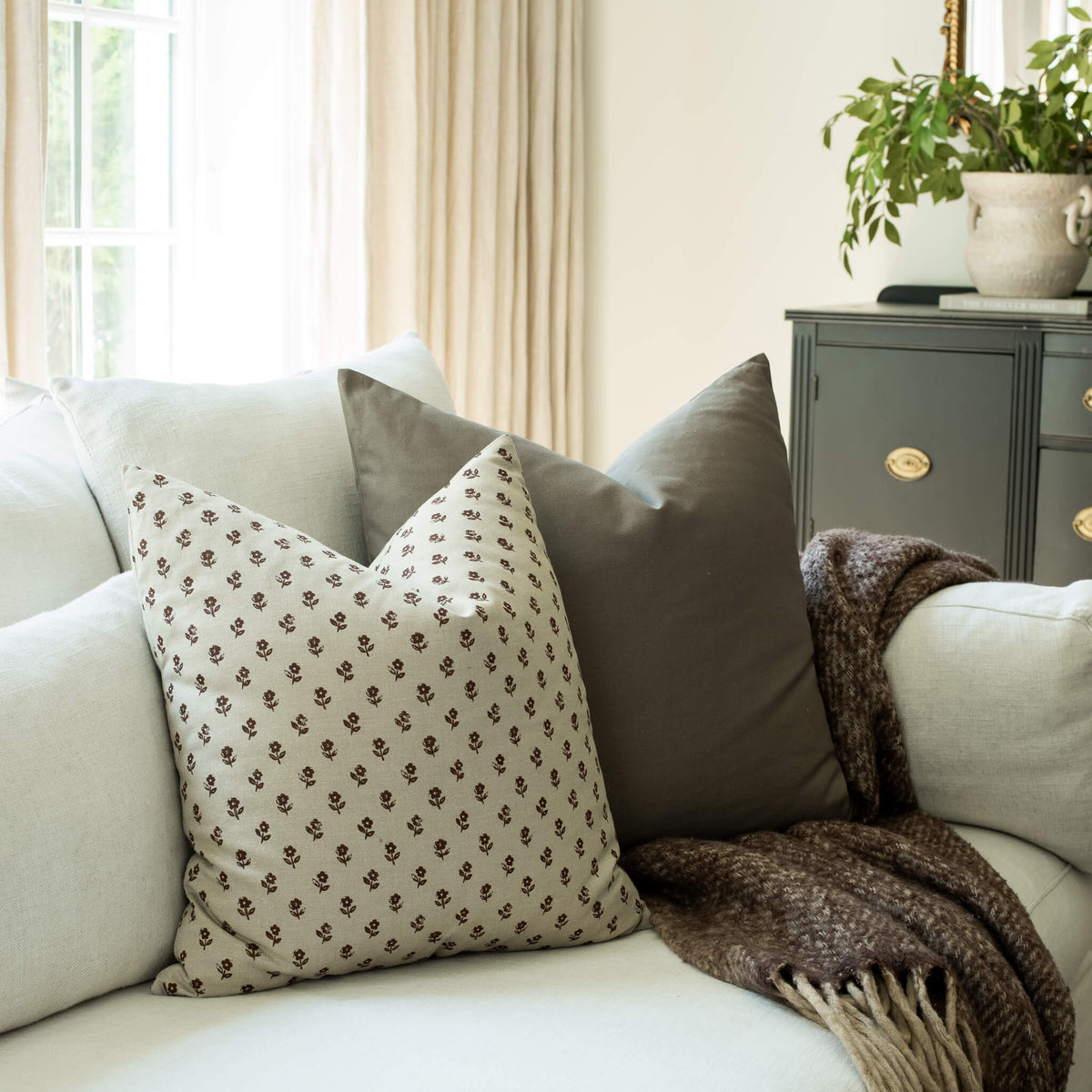 Pippa brown ditsy block print throw pillow cover on a sofa