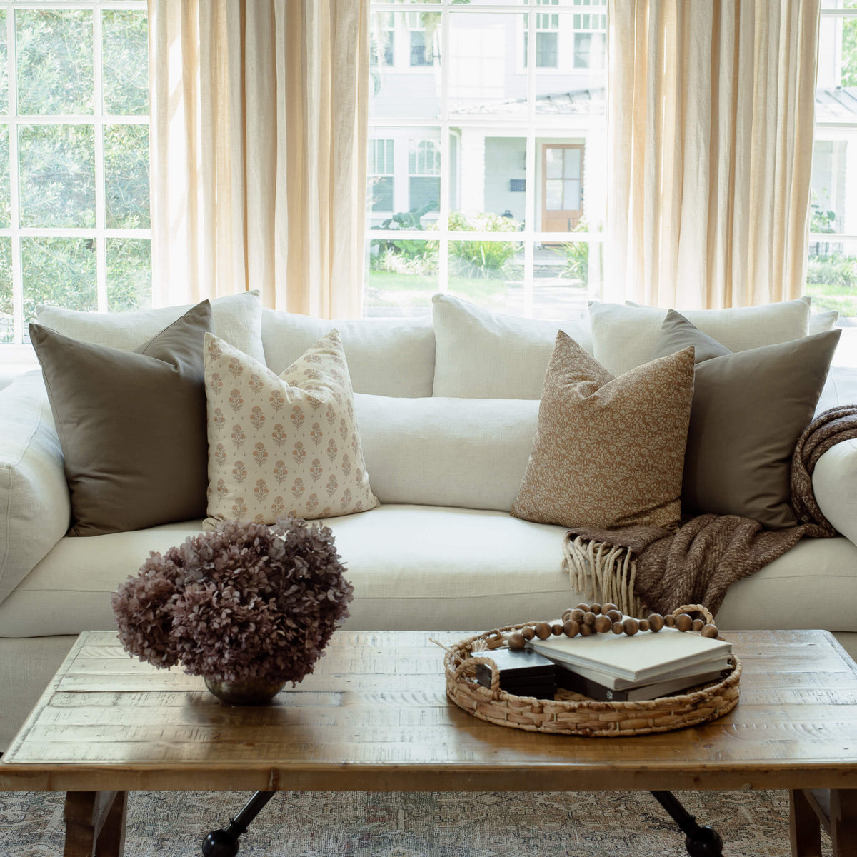 Louisa brown floral pillow styled on an organic modern sofa