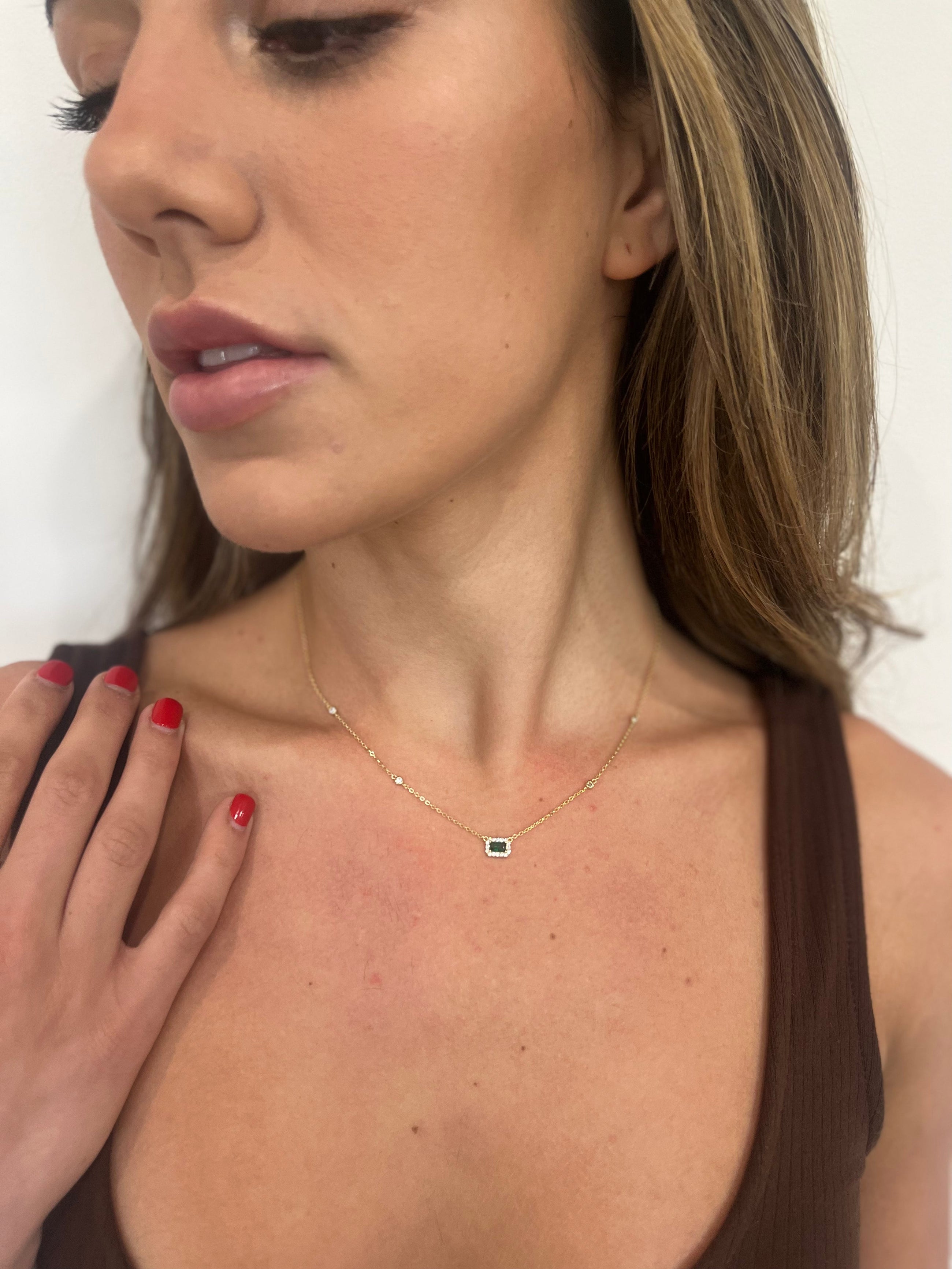 Close-up of emerald CZ stones on dainty necklace