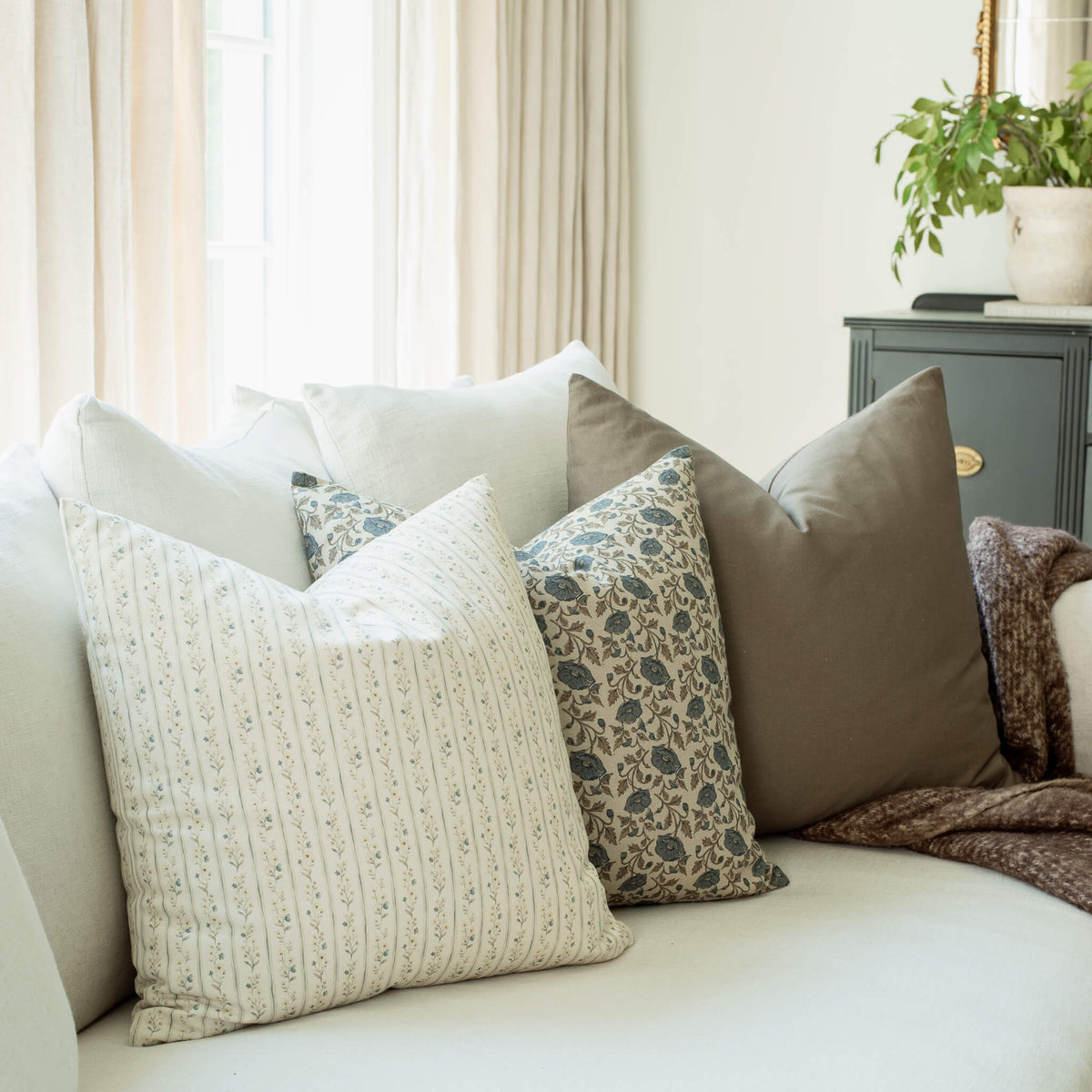 Amelia set with ivory striped and blue floral pillows on a sofa