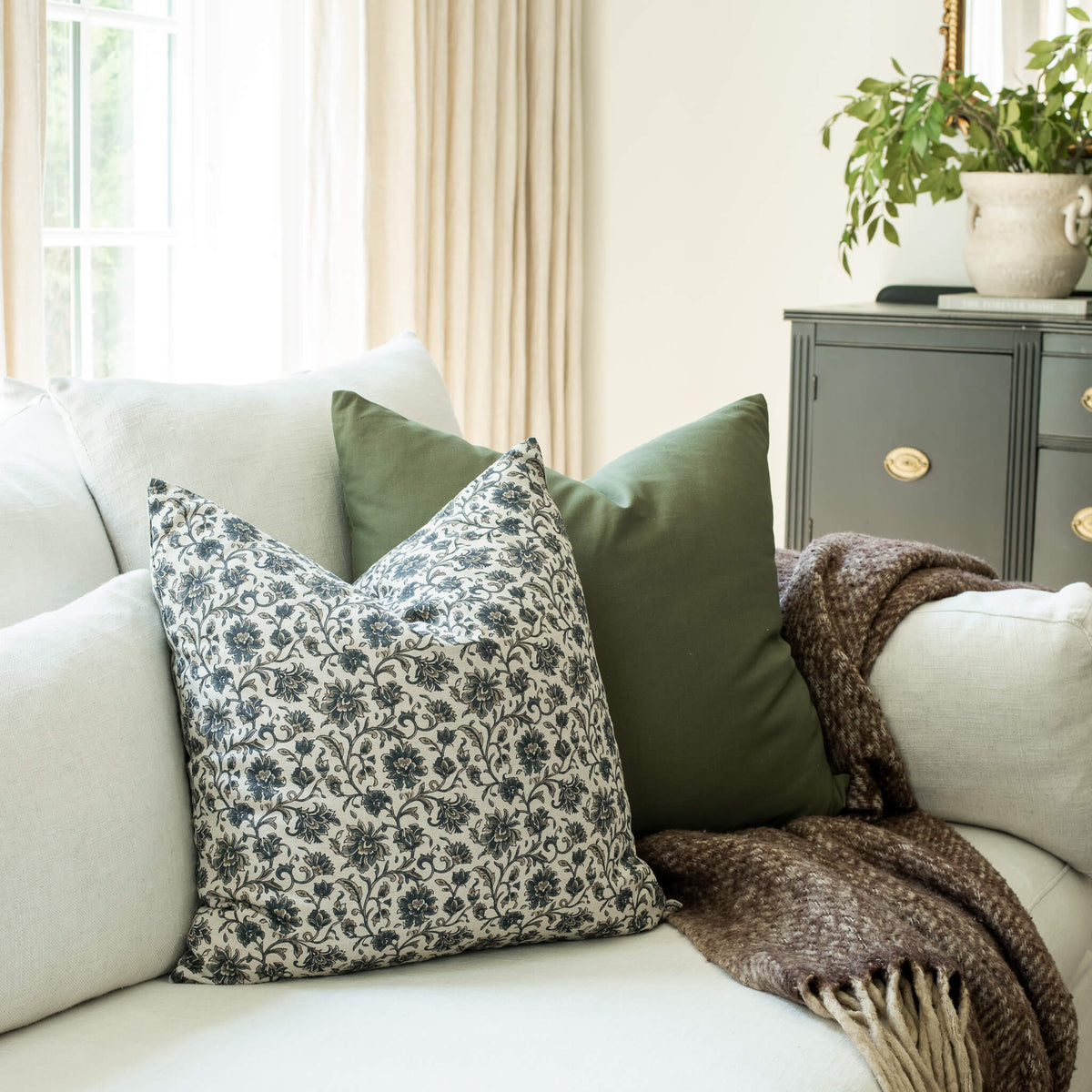 Celine navy blue vintage floral throw pillow cover on a sofa