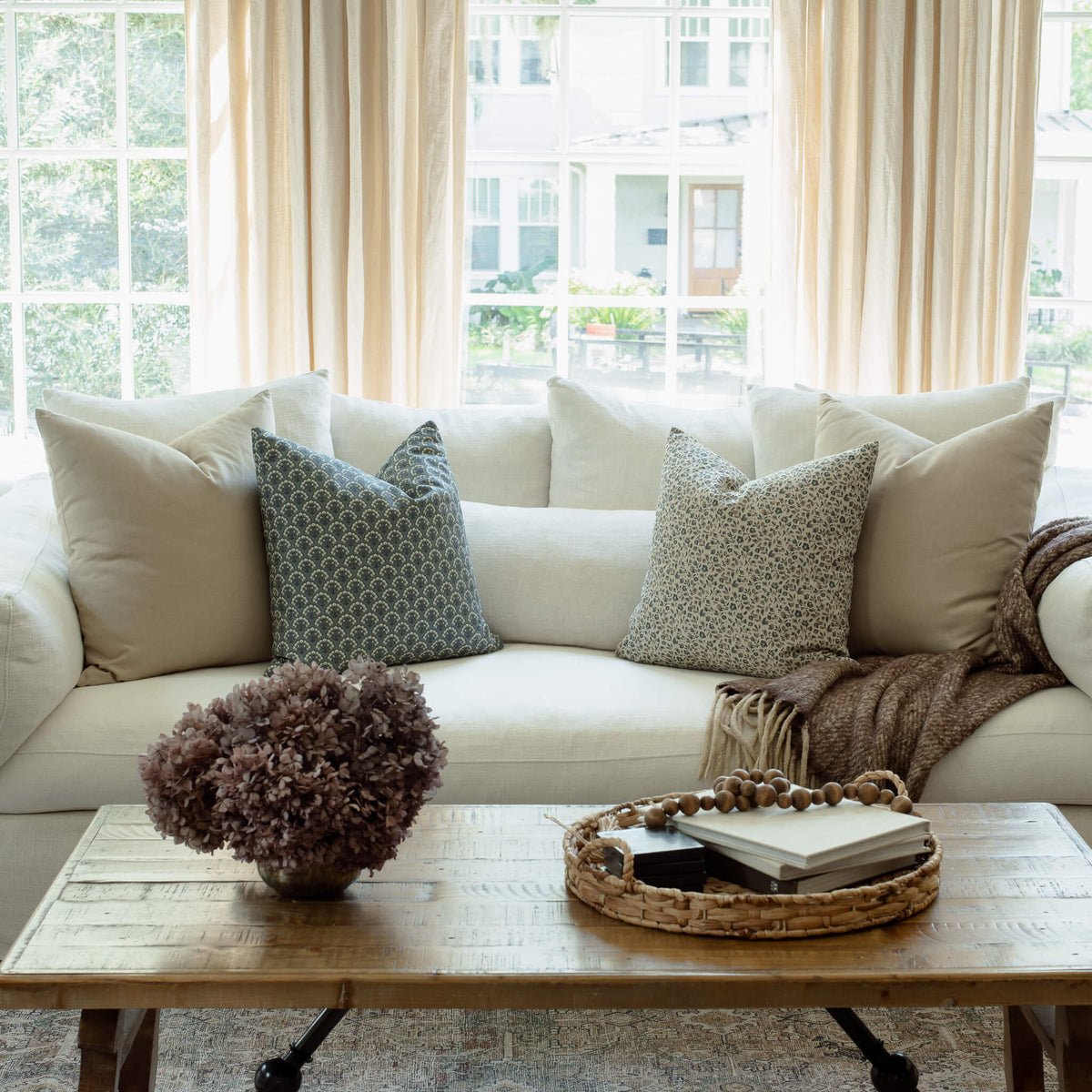 Noelle indigo floral pillow styled on an organic modern sofa