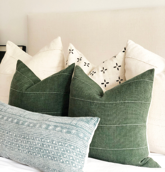 designer jewel low maintenance pillow covers for the bedrooms, greens and neutral pillows on bed. 