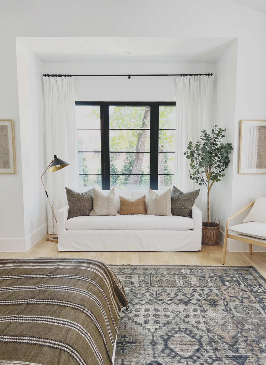 white room with brown sheets on bed