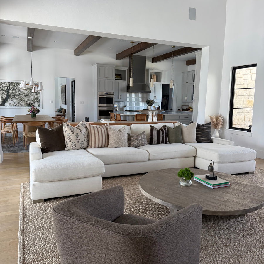 designer pillow covers on neutral sofa in living room