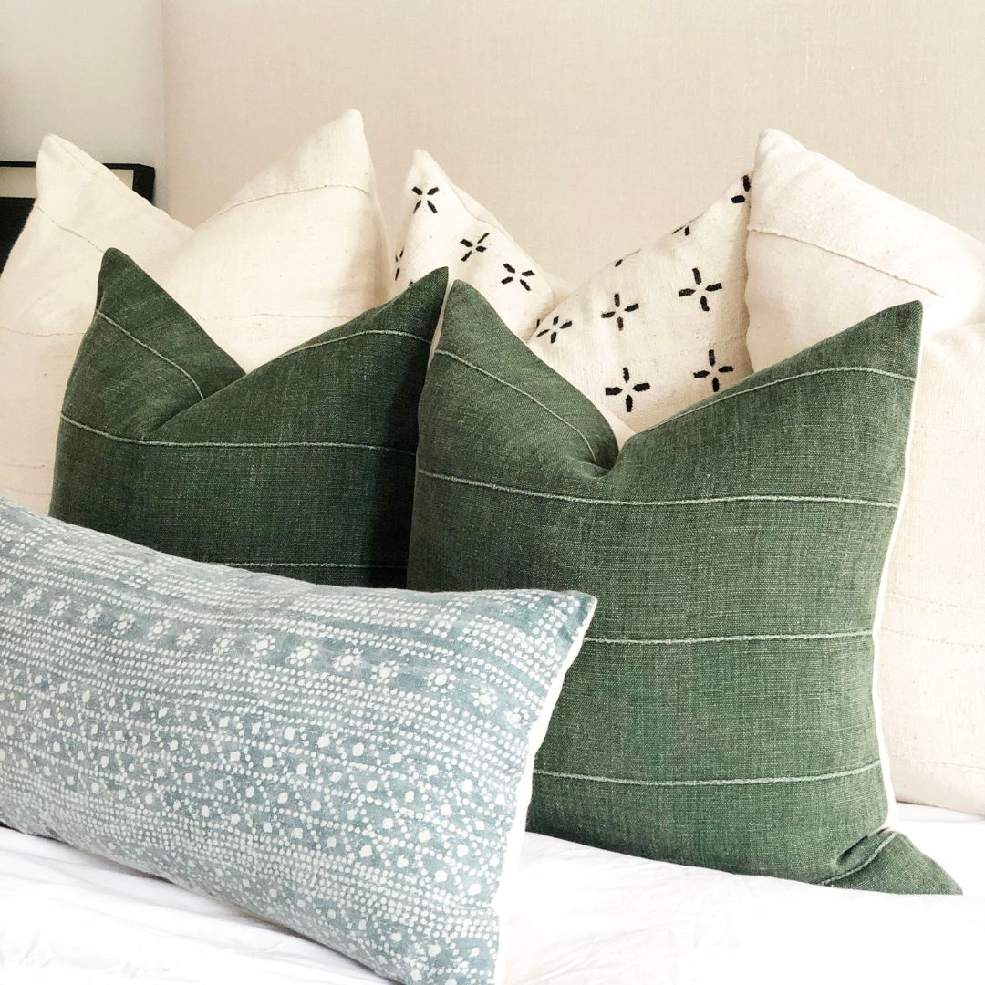 6 throw pillows stacked on the bed