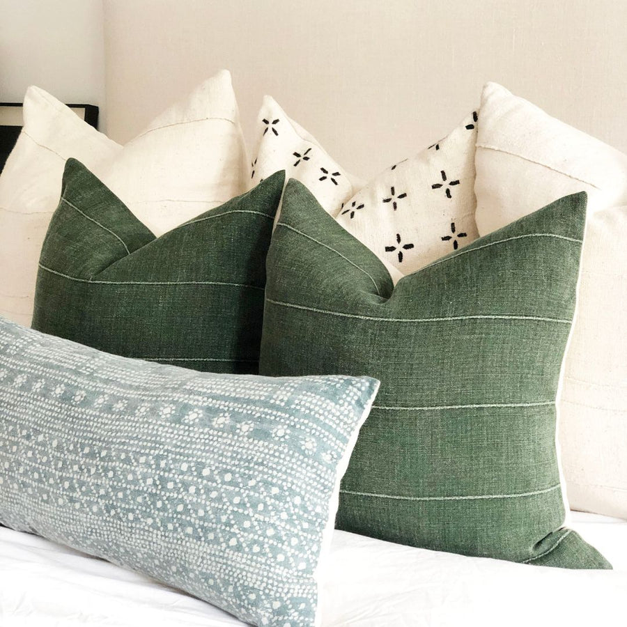 6 throw pillows stacked on the bed