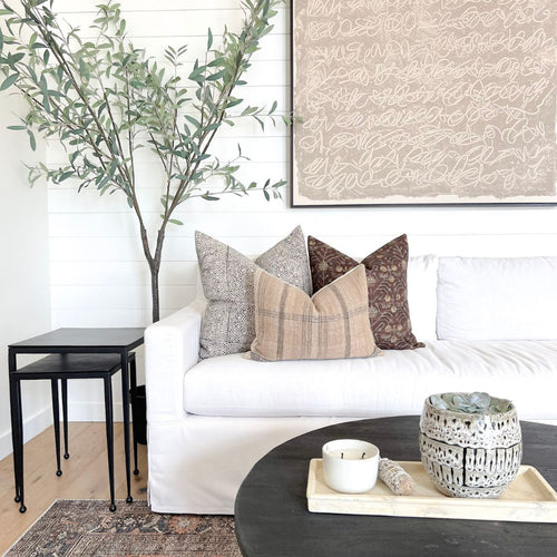Three throw pillows on a sectional couch in the living room