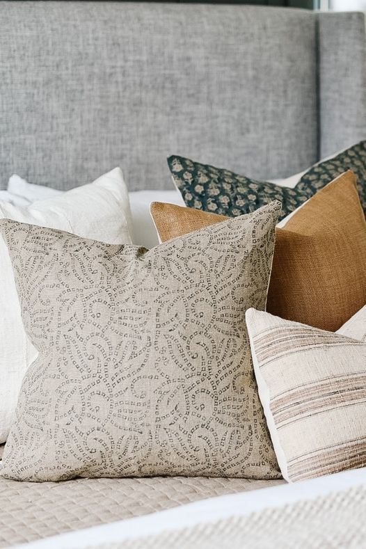 grey, orange, green, and white pillow on couch outside