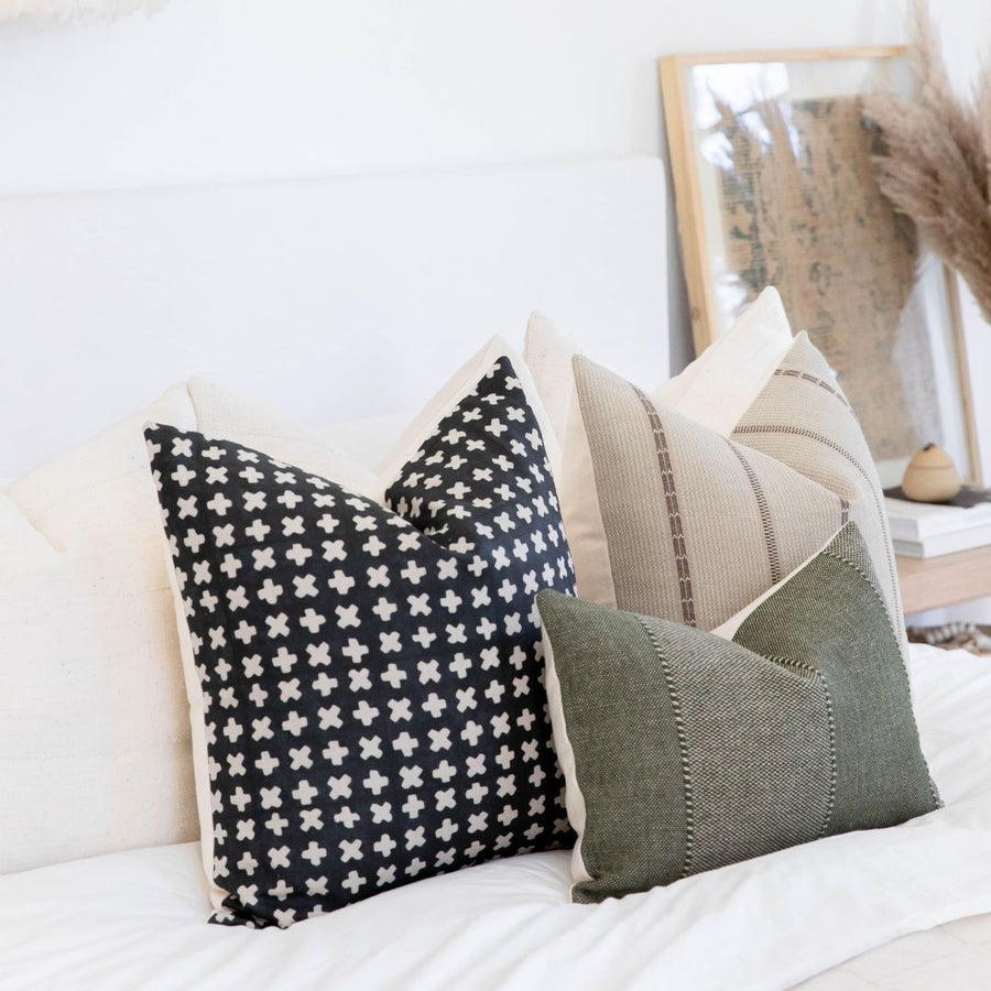 Throw Pillow set resting on a white bed
