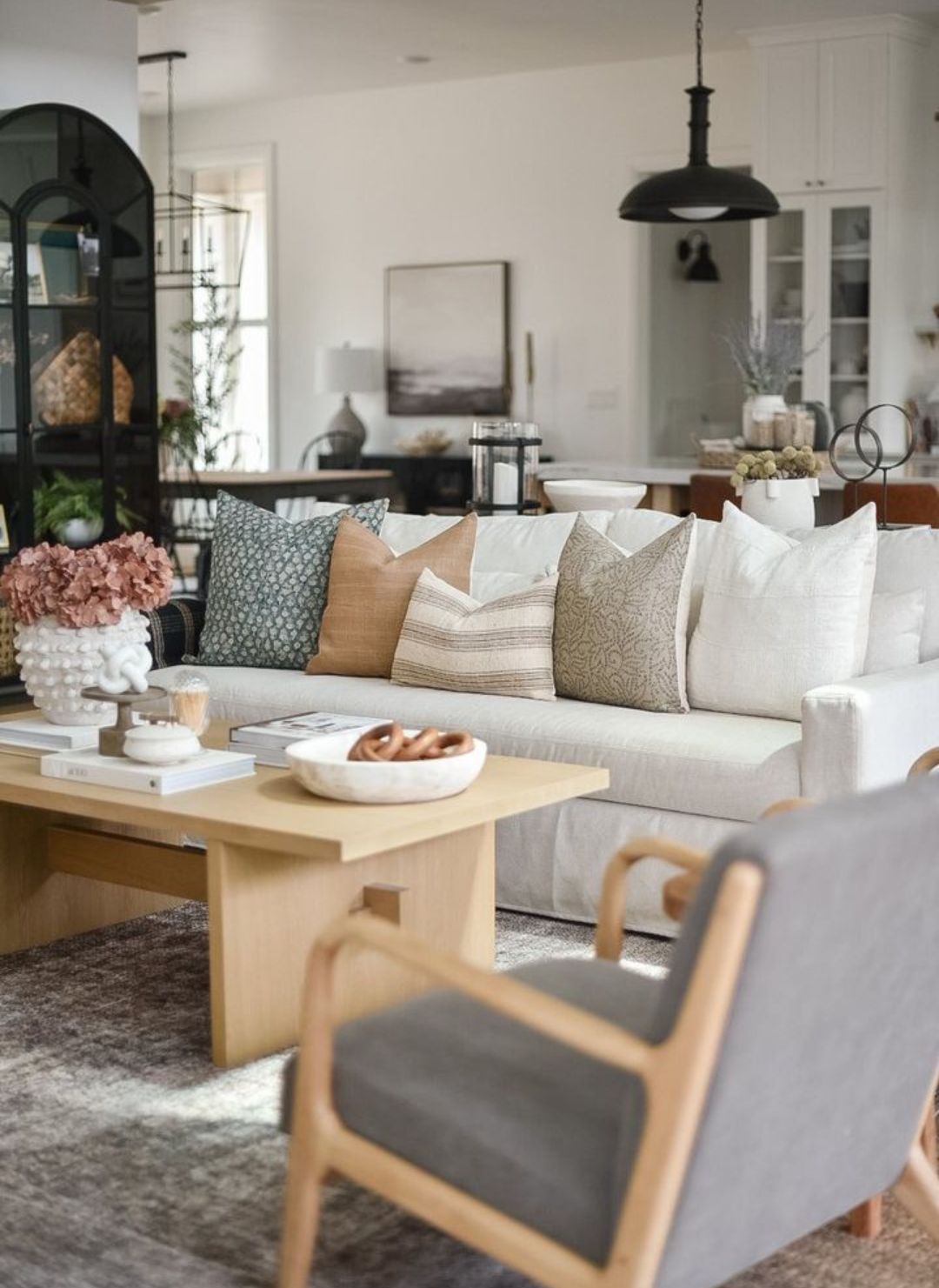 designer throw pillows all spread out on a couch with an open book in front of them