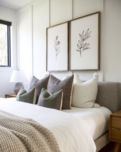 seven white and gray designer throw pillows on a bed