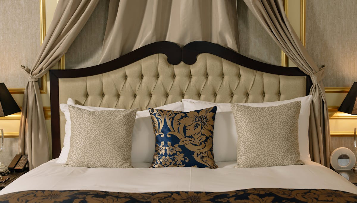 a king bed with a bunch of pillows on top of it