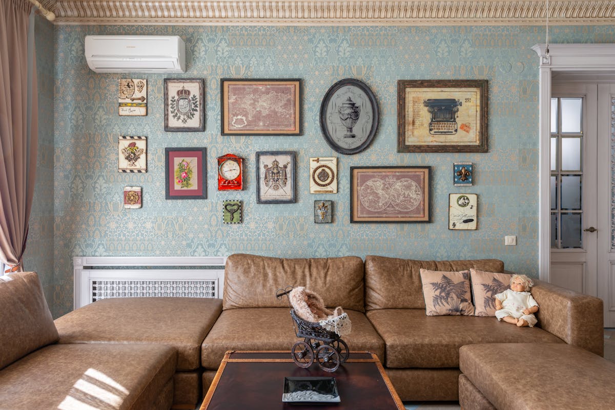 a tan couch in a vintage room in a house with pillows on it