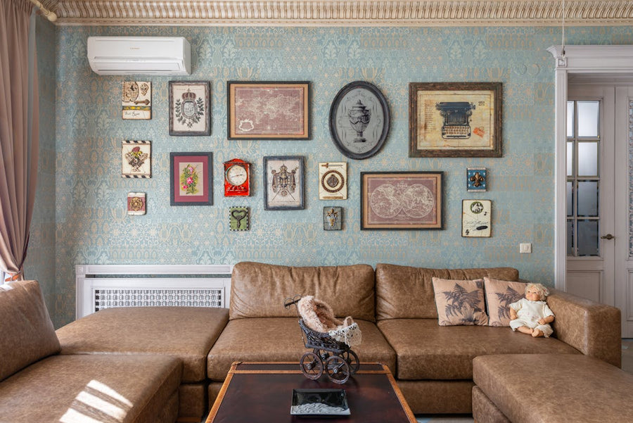 a tan couch in a vintage room in a house with pillows on it