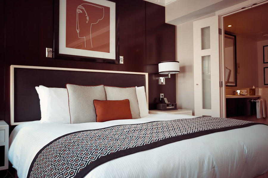 a bed with a bunch of pillows sitting on top of it