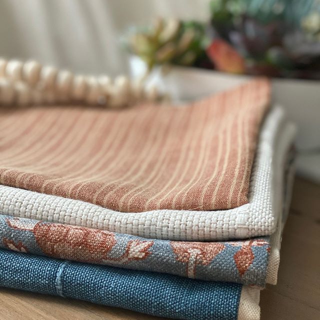 stack of rust linen pillow cover on a table close up of the fabric