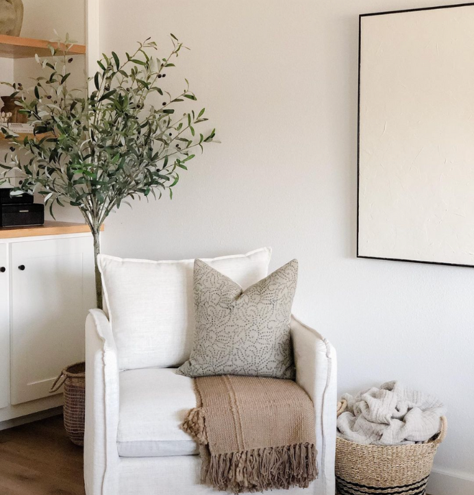 cream and white pillow on cream accent chair in living room
