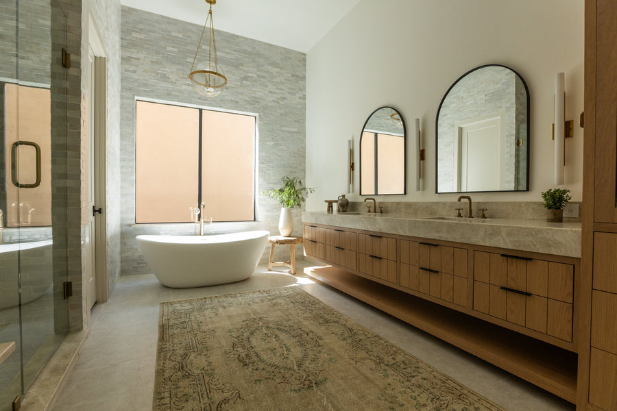 bathroom with wood cabinetry and stone sink and bathtub