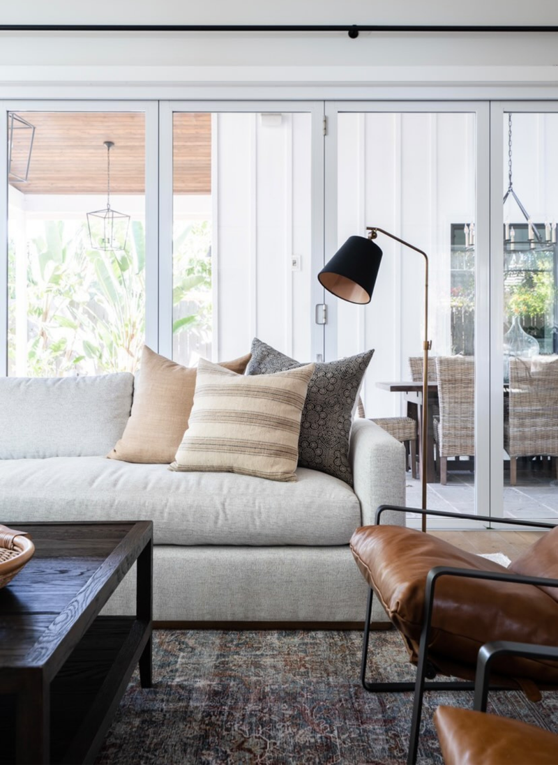 layered decorative pillows styled on a bright modern sofa creating an inviting airy living space.