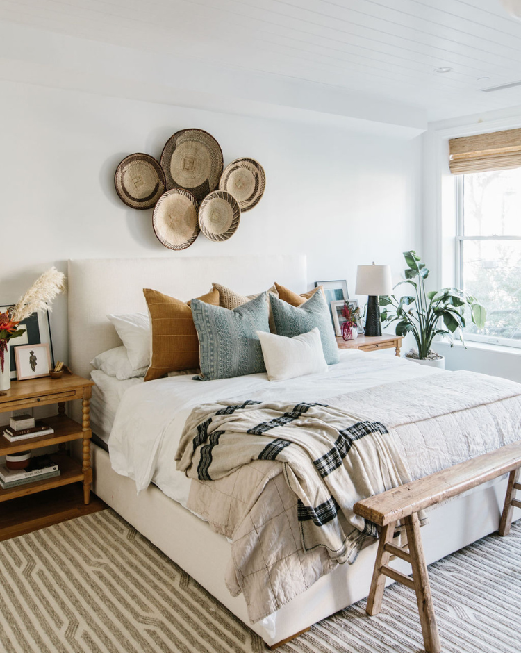 earth tone decorative pillows styled on a cozy bedroom bed with textured bedding, throw blanket and modern home decor accents with neutral rug and art.