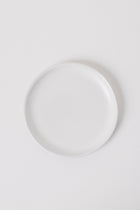 Minimalist matte white appetizer plates styled on a table