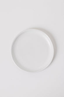 Minimalist matte white appetizer plates styled on a table