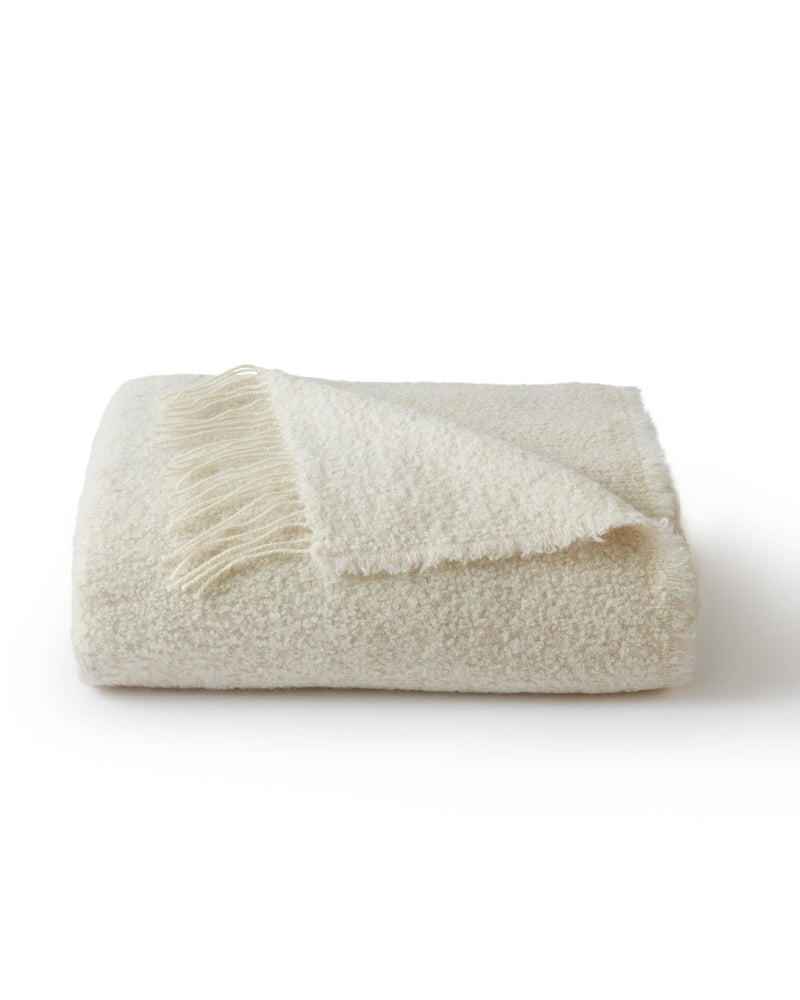 Beige blanket with fringed edge on a white background