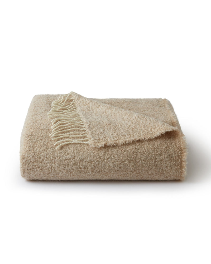 Beige blanket with frayed edge on a white background