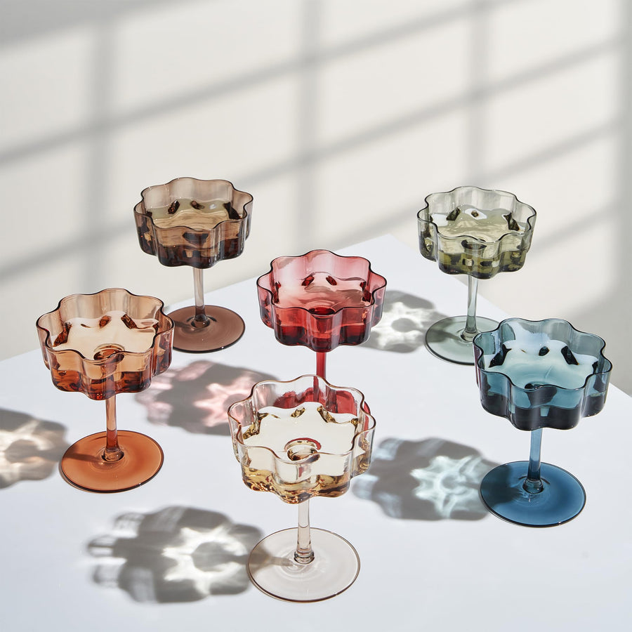 Cranberry, blue, grey, beige, green, and orange coupe cocktail glasses