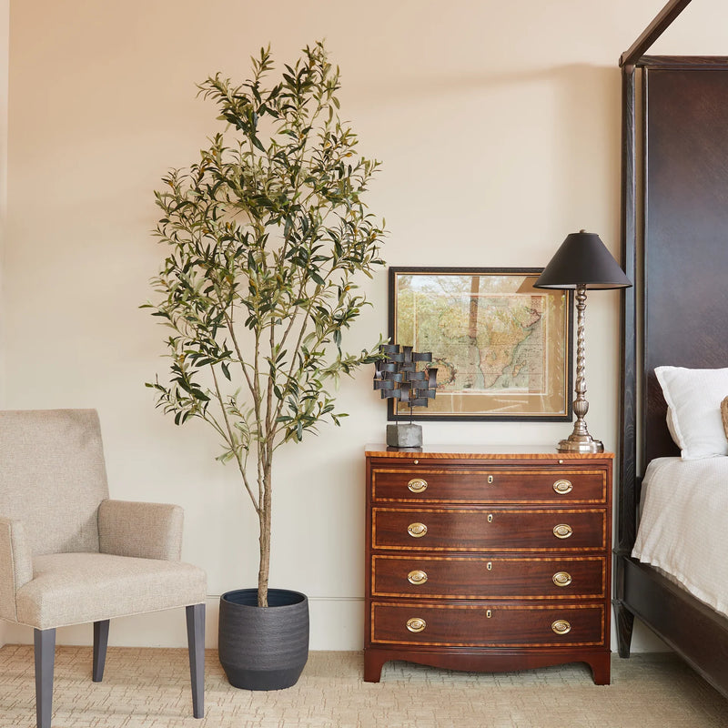 Tall faux olive tree styled in modern living room