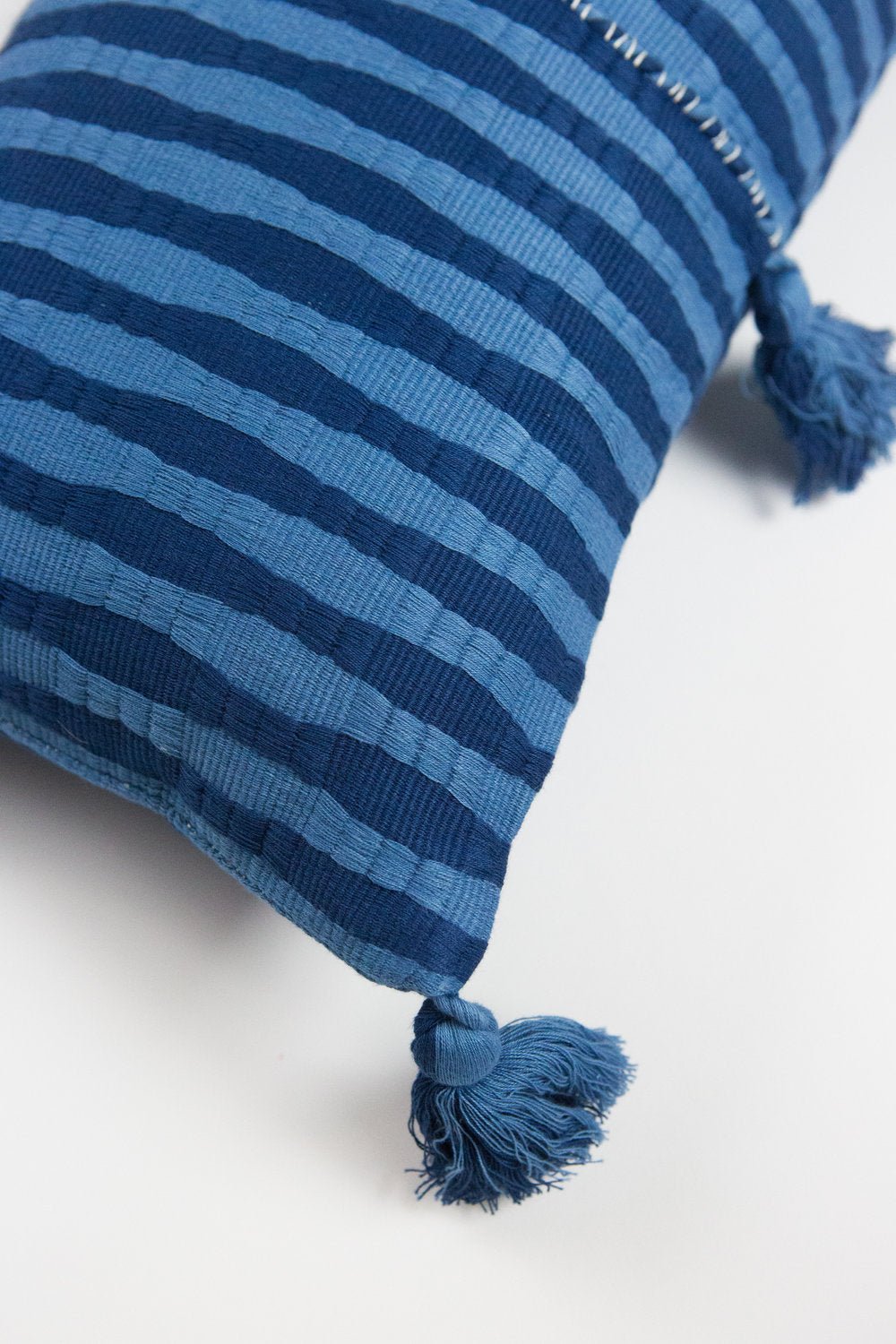 Close-up of the handwoven Antigua pillow in natural indigo stripe