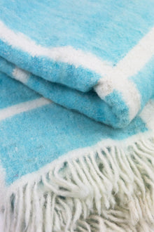 Momos Grid felted wool blanket in aqua blue and natural white, folded