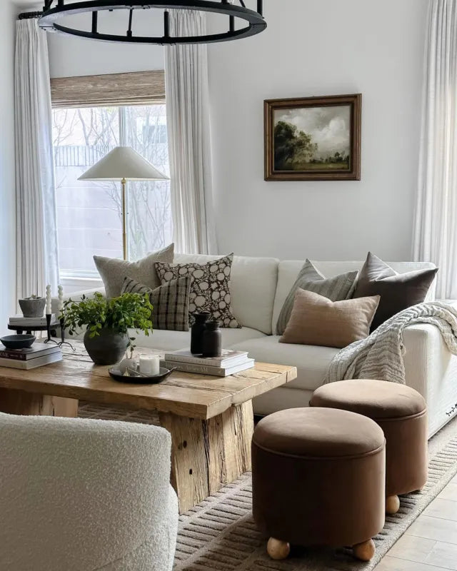 Cozy living room styled with layered neutral decorative pillow covers on white sectional with decorative home decor by One Affirmation