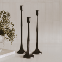 Elegant cast iron taper candle holder set on dining table