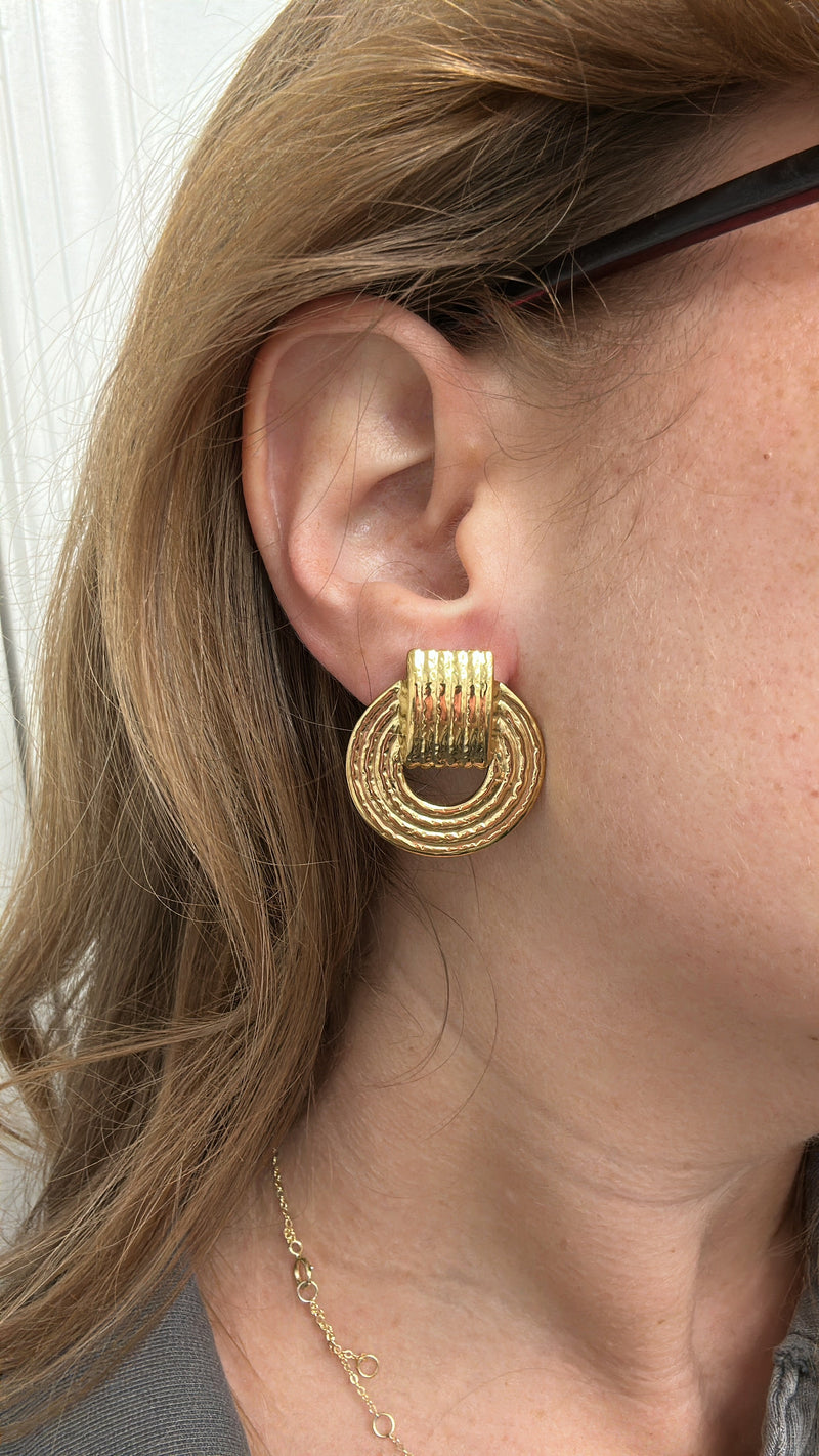 Close-up of gold vintage-inspired doorknocker earrings