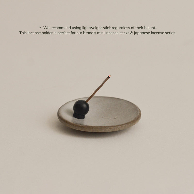 Modern spherical incense holder with matte black finish and brass detail