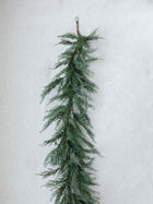 Artificial cedar greenery draped on mantel