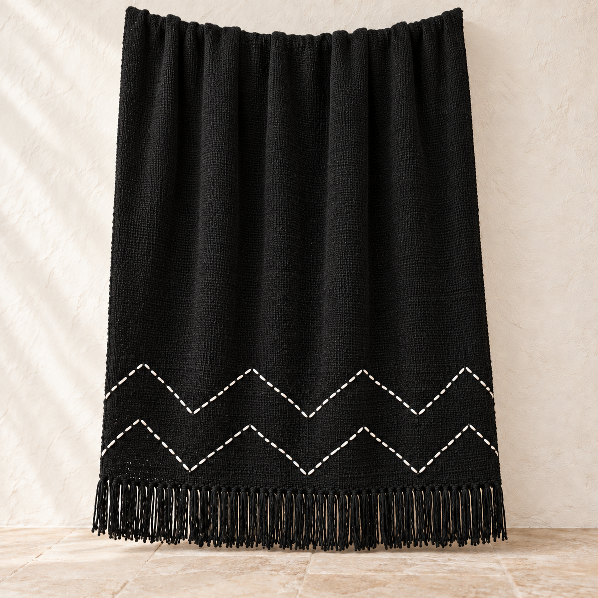 Black chevron cotton throw with white hand-stitched zigzag pattern