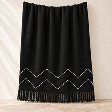 Black chevron cotton throw with white hand-stitched zigzag pattern
