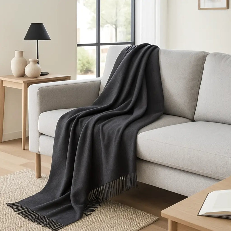 Grey Mongolian cashmere throw blanket draped over a sofa