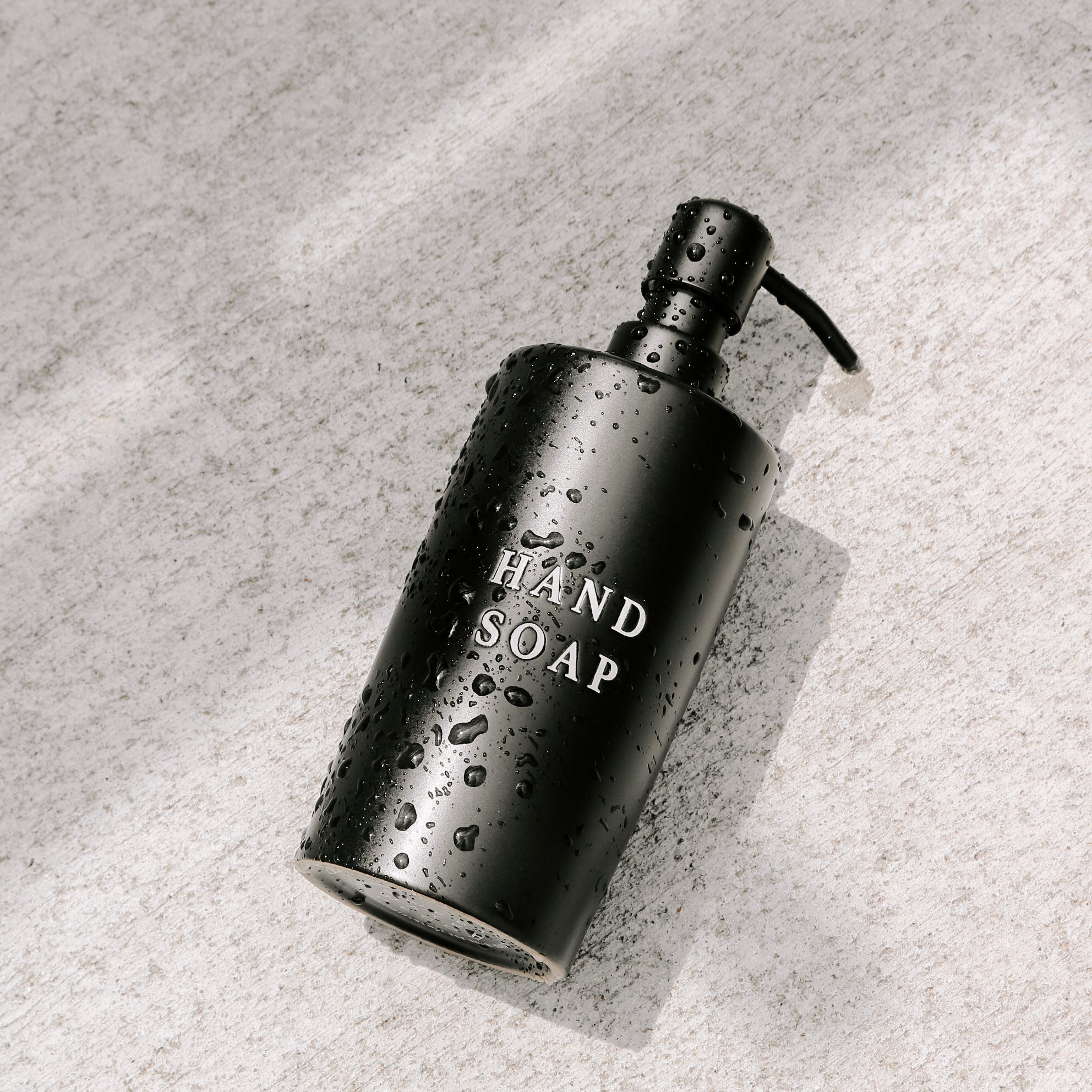 Modern black soap dispenser with embossed “Hand Soap” text