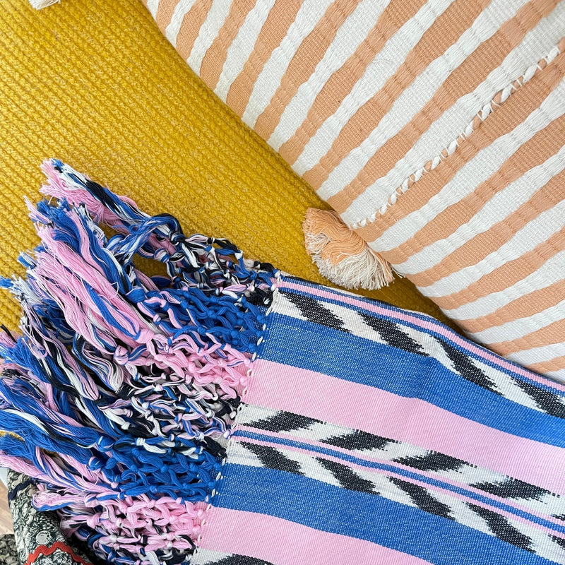 Palm ikat blanket in blue and pink styled in a home interior