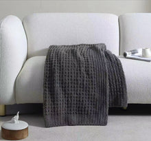 Soft waffle weave throw draped over sofa arm