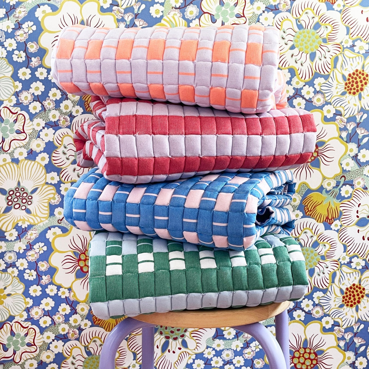 Quilted Sujani throw blanket in soft lilac and red styled in a home interior