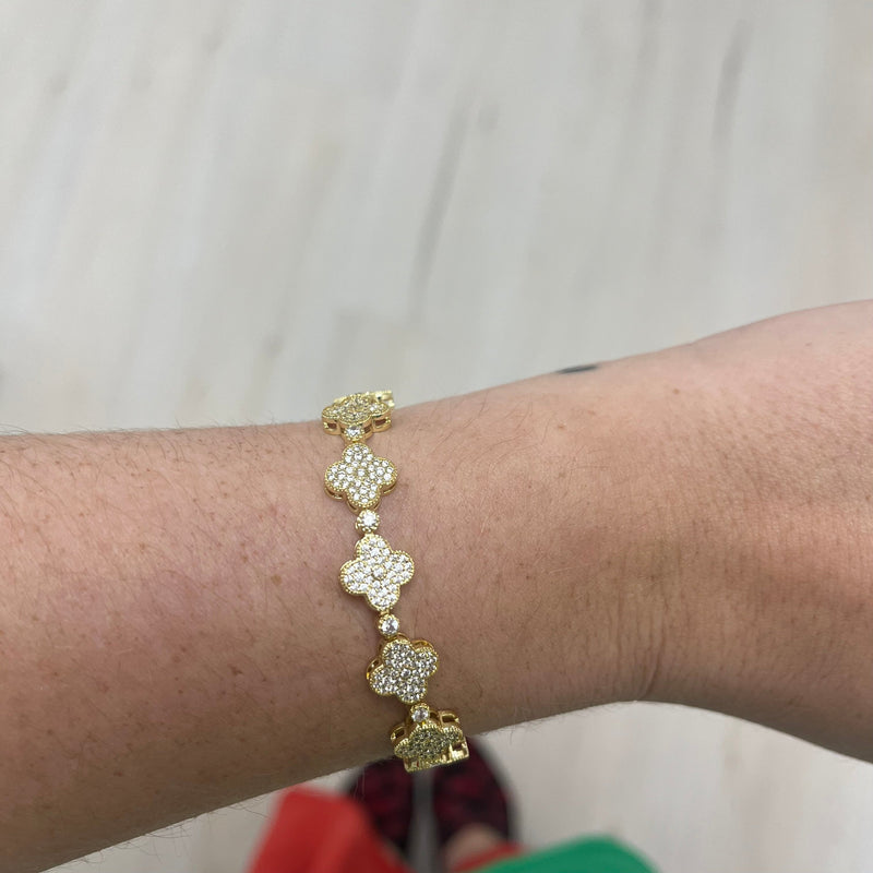 Close-up of CZ clover detailing on gold tennis bracelet