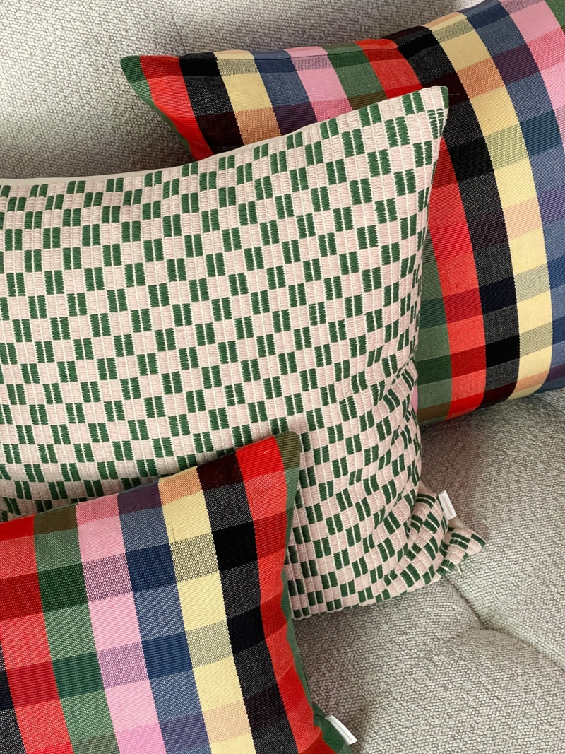 Checkered brocade pillow in green and cream styled in a home interior